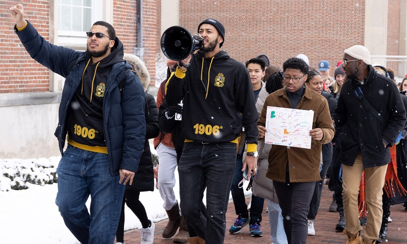 Tewoflos Tewoldeberhan ’25, holding a megaphone, prepares to lead the march outside of Slayter Hall.
