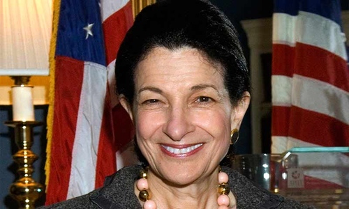 A portrait photo of Olympia Snowe posing with an American flag in the background