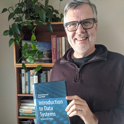Associate Professor Thomas Bressoud with the new textbook Introduction to Data Systems.