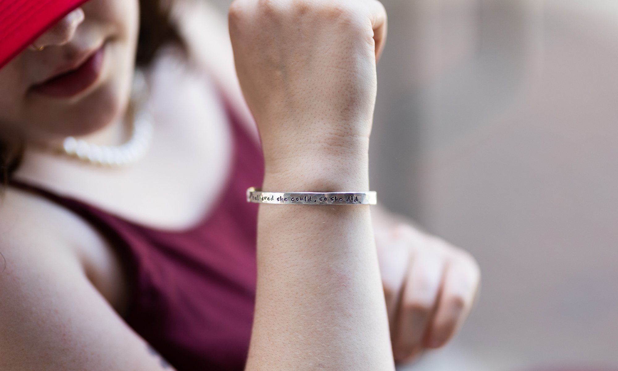 A silver bracelet, inscribed with the quote She believed she could, so she did