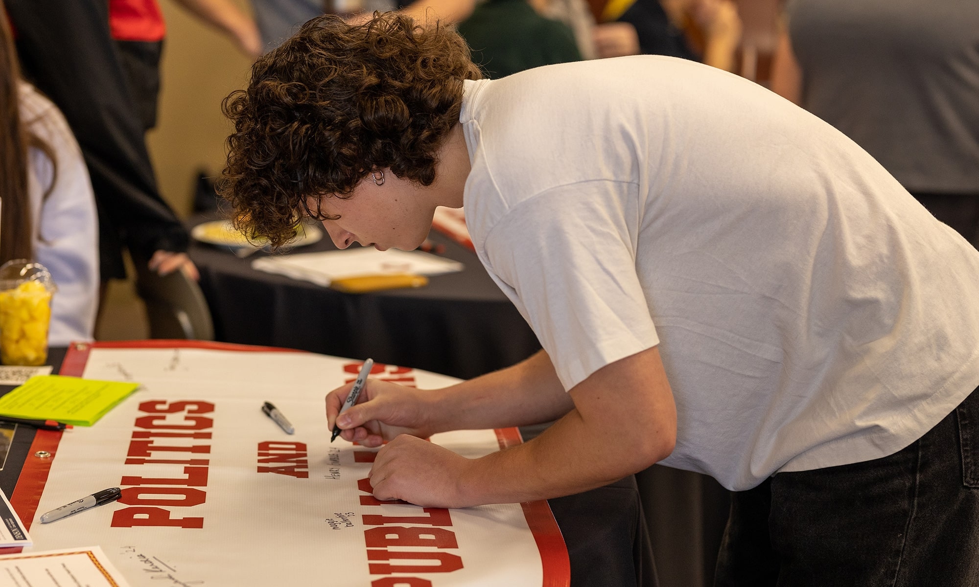 Student signing a banner