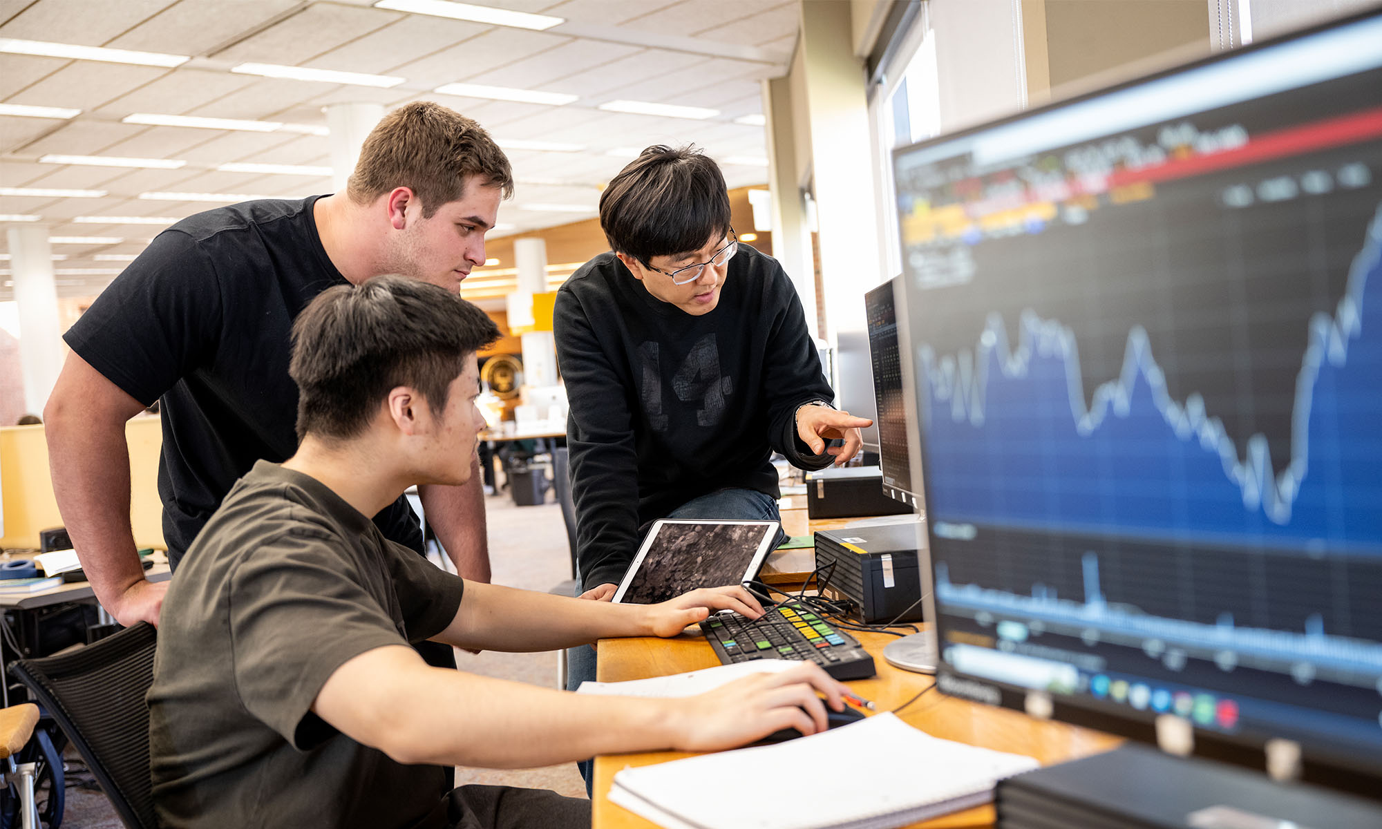 Students work at Bloomberg terminals with their professor