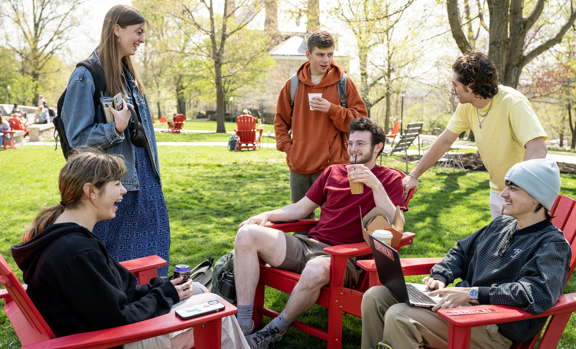 Picture of college students sitting on chairs outside and having a conversation