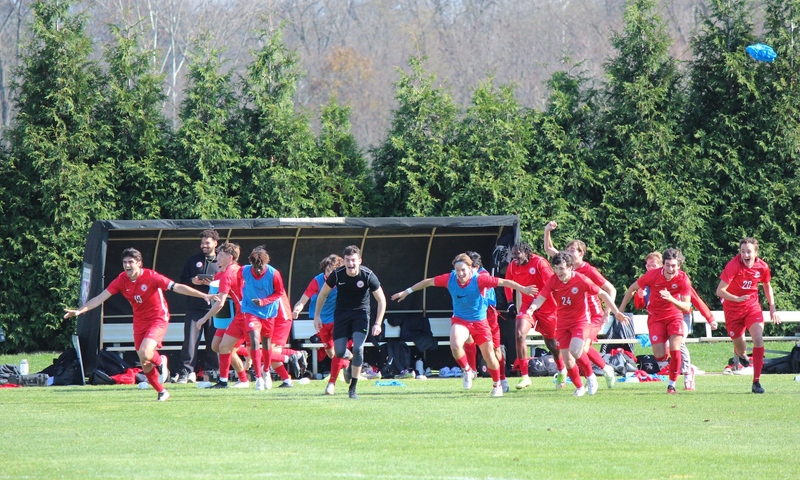 Members of the mens soccer team run off the bench to celebrate a conference tournament championship. (Shannon OBrien)