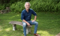 Amor Towles sitting on a bench